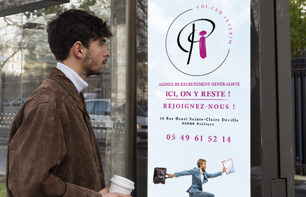 Une personne regarde la publicité de l'agence Pictav Intérim sur un abris de bus, dans Poitiers.